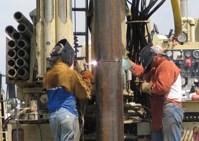 Driller and his assistant are welding 12" casing on site for an industrial well