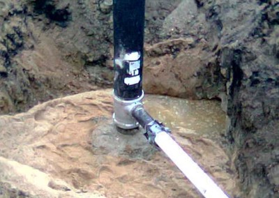 Pitless hookup with a sleeve to water main on a municipal application