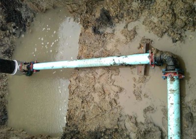 Pitless hookup and water main for a municipal well