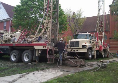 Drilling a loop field in close proximity to an existing building and other structures